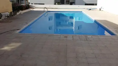 a swimming pool with blue water in a house at Poseidon Apartment by Michalis in Ayia Napa