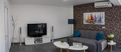 a living room with a couch and a tv at Poseidon Apartment by Michalis in Ayia Napa