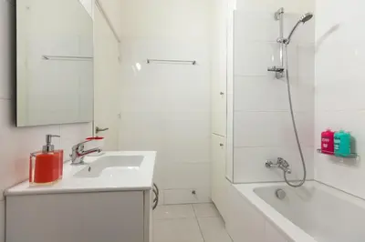 a white bathroom with a sink and a shower at Myrtiana Apartments in Nicosia