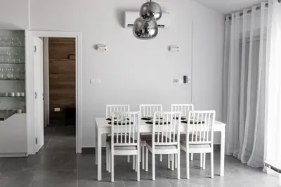 a white dining room with a white table and chairs at Bayview Terraces in Limassol