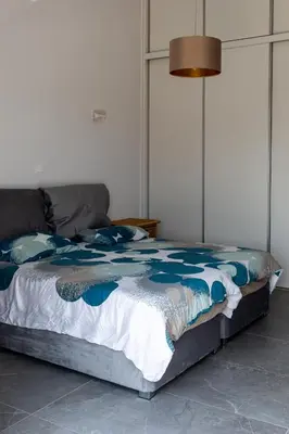 a bed with a blue and white comforter in a room at Bayview Terraces in Limassol