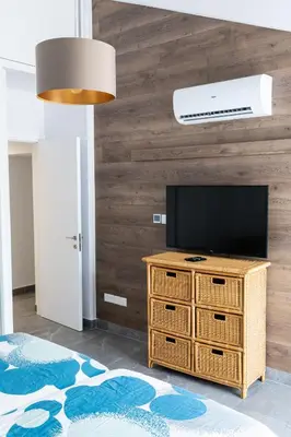 a living room with a television on a wooden wall at Bayview Terraces in Limassol