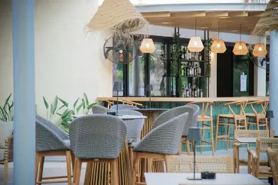a restaurant with chairs and tables and a bar at Odysseia Hotel Kapetanios in Limassol