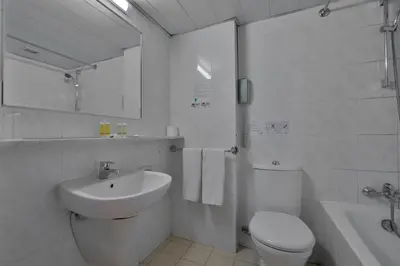 a white bathroom with a toilet and a sink at Odysseia Hotel Kapetanios in Limassol