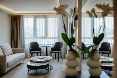 a living room with a couch and a table and chairs at Odysseia Hotel Kapetanios in Limassol