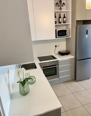 a kitchen with white cabinets and a white counter top at Mythical Sands Resort - Antonios in Paralimni