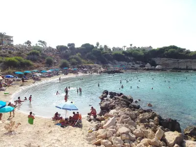 a group of people swimming in the water at a beach at Mythical Sands Resort - Antonios in Paralimni