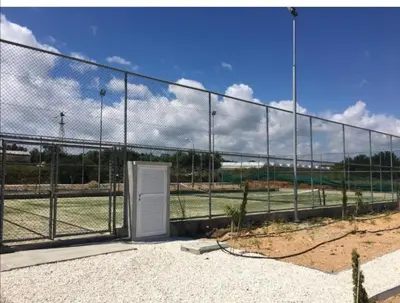 a fence with a door in front of a baseball field at Mythical Sands Resort - Antonios in Paralimni