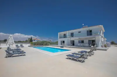 a villa with a swimming pool and lounge chairs at Villa Marylou in Protaras