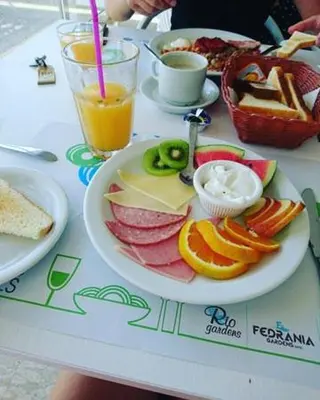 a table with a plate of food on a table at Fedrania Gardens Hotel in Ayia Napa