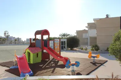 a playground with a slide and a slideintend at Fedrania Gardens Hotel in Ayia Napa