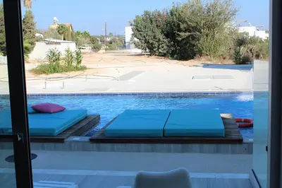 two beds on the side of a swimming pool at Fedrania Gardens Hotel in Ayia Napa