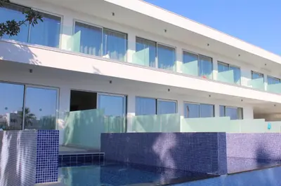 a building with a swimming pool in front of it at Fedrania Gardens Hotel in Ayia Napa
