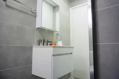 a bathroom with a white cabinet and a shower at Lazuli Sea View Beachfront Ap 43 in Larnaka