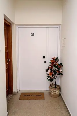 a white door with a plant in front of it at Lazuli Sea View Beachfront Ap 21 in Larnaka