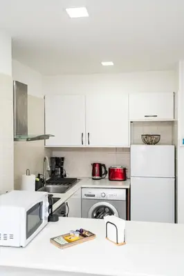 a kitchen with white appliances and white cabinets at Lazuli Beach & Pool Apartment 501 in Larnaka