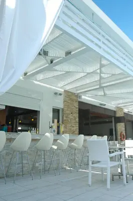 a group of white chairs and tables in a building at Senator Hotel Apartments - Adults Only in Ayia Napa