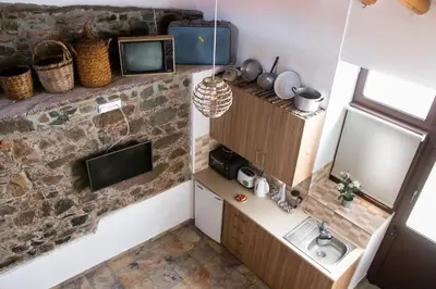a small room with a sink and a tv on a wall at AgroSpito Traditional Guest House in Agros