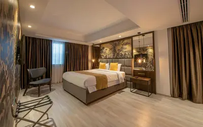 a hotel room with a bed and a chair at Almond Business Hotel in Nicosia