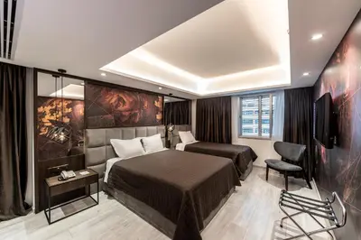 a bedroom with a bed and a tv and a chair at Almond Business Hotel in Nicosia