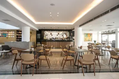a restaurant with tables and chairs and a bar at Crystal Springs Beach Hotel in Protaras