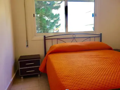 a bedroom with an orange bed and a window at Andreas Apartment in Limassol