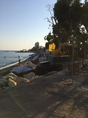 a beach with boats on the sand and the water at Billis Beach Apartment in Limassol