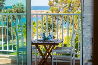 a table and chairs on a balcony with a view of the ocean at Villa Ricky in Protaras