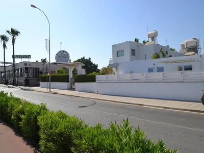 a white building on the side of a street at Makronissos Beach Studio in Ayia Napa