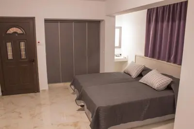 a bedroom with a large bed and a door at Makronissos Beach Studio in Ayia Napa