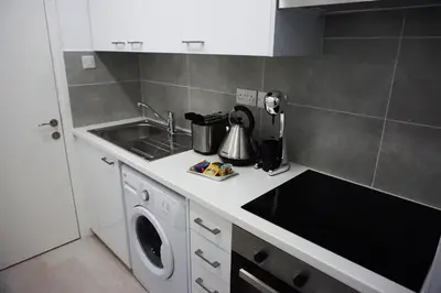 a kitchen with a sink and a washing machine at Lazuli Sea View-Beachfront Ap 405 in Larnaka