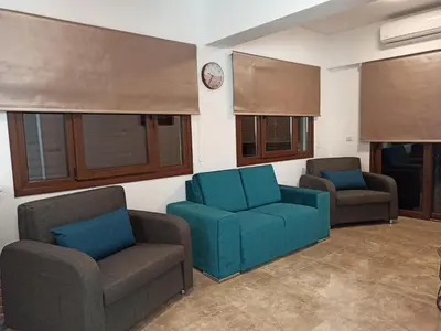 a living room with two chairs and a blue couch at River Apartments in Galata