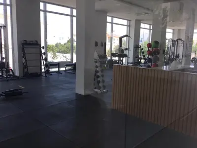 a gym with black tile floors and large windows at Apartment Helena in Paralimni