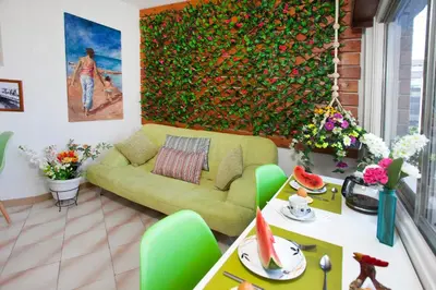 a living room with a green couch and a painting at Artemis Boutique Apartment 1 in Limassol