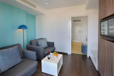 a living room with a couch and a tv at Nestor Hotel in Ayia Napa