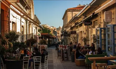 a group of people sitting in chairs on a street at The Stable in Limassol