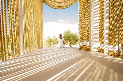a woman in a white dress is standing on a bridge at Aelia Wellness Retreat in Nicosia