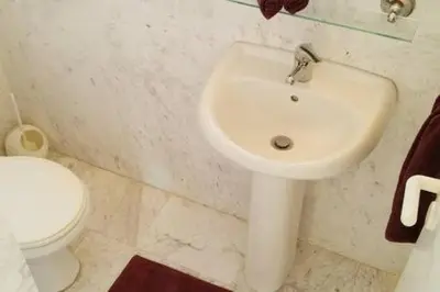 a bathroom with a white sink and a toilet at Larnaka Beach House 3 in Larnaka