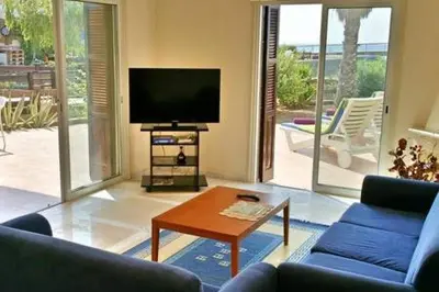 a living room with a tv and a couch and a table at Larnaka Beach House 3 in Larnaka