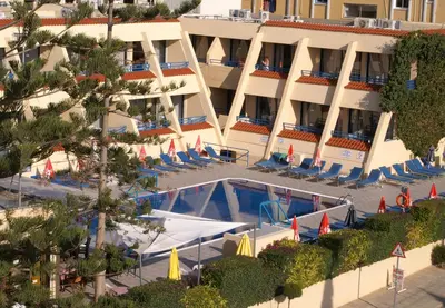 a resort with a swimming pool and chairs and a building at Napa Prince Hotel Apts in Ayia Napa