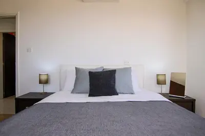 a bedroom with a large bed with two lamps at Seaside Luxury Flat Pervolia in Pervolia