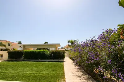 a garden in front of a house with purple flowers at Seaside Luxury Flat Pervolia in Pervolia
