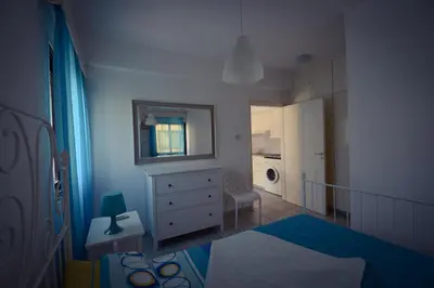 a bedroom with a bed and a dresser and a mirror at Krasas Beach Flats in Larnaka