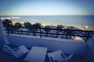 a balcony with chairs and a view of the beach at Krasas Beach Flats in Larnaka