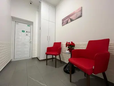 two red chairs sitting in a waiting room at Apollo Rooms by Albert's Apartment in Larnaka