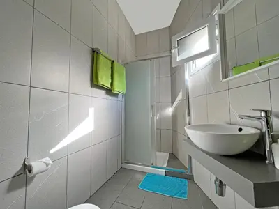 a bathroom with a white sink and a mirror at Apollo Rooms by Albert's Apartment in Larnaka