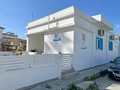 a white house with a fence and a car at Apollo Rooms by Albert's Apartment in Larnaka