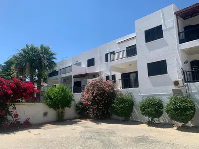 a white apartment building with flowering plants in front of it at Theodoros Apt. 408 in Protaras