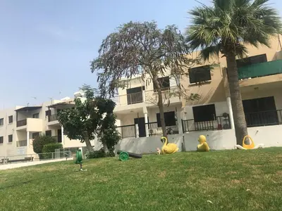 three rubber ducks sitting in the grass in front of a building at Theodoros Apt. 408 in Protaras