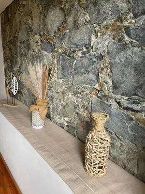 three vases sitting on a shelf in front of a stone wall at Theoxenia in Kalopanayiotis